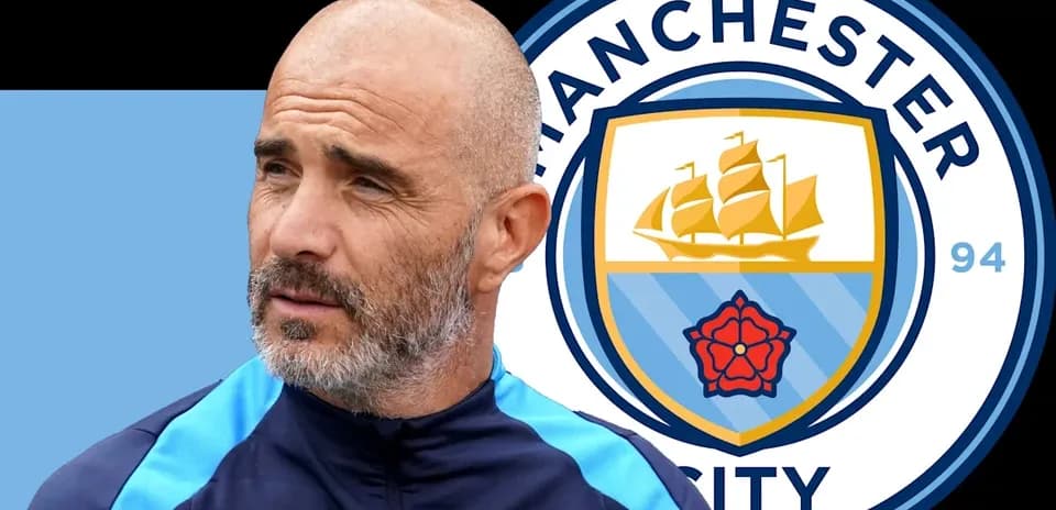 Coach standing next to Manchester City logo