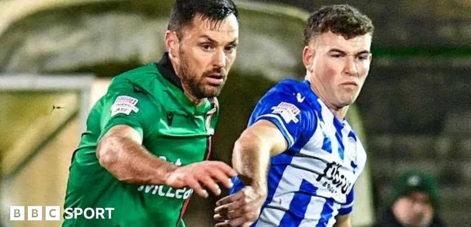 Two football players competing for possession of the ball