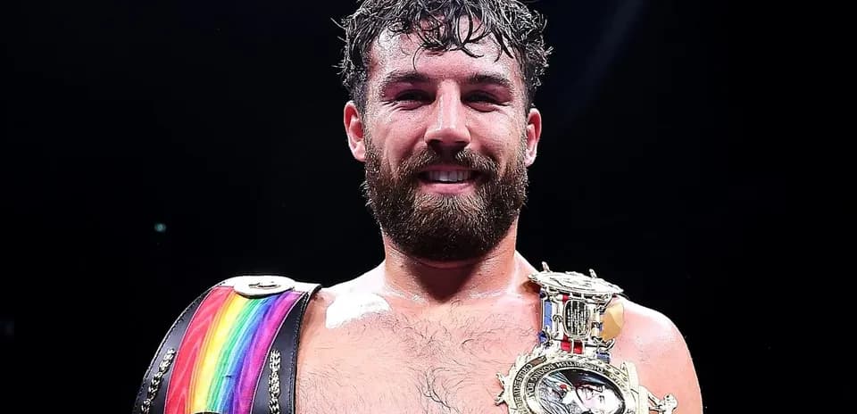 Boxer holding championship belts and smiling
