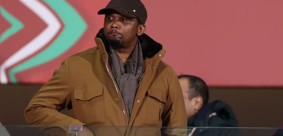 Man in brown coat observing an event