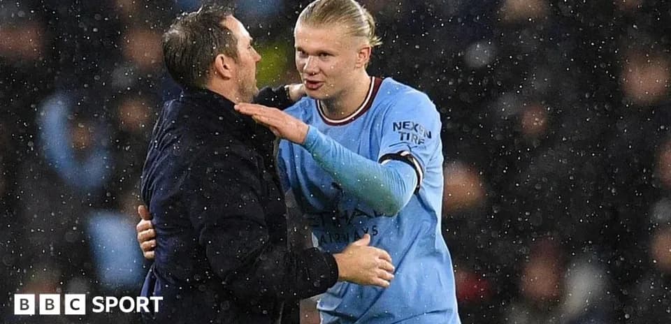 Player and coach embracing during rainy match