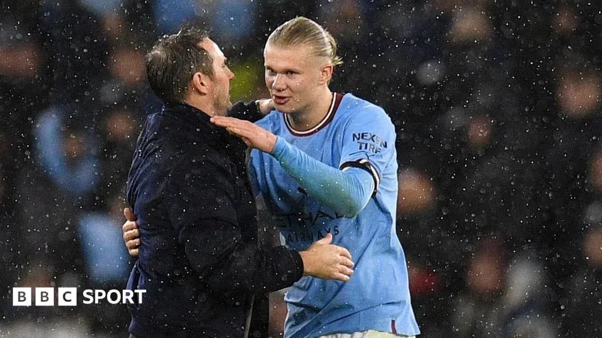 Player and coach embracing during rainy match