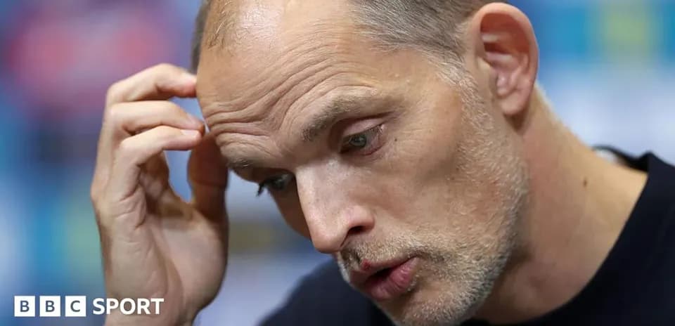 Manager speaking at press conference with hand on forehead