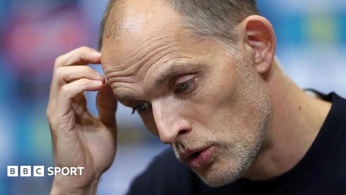 Manager speaking at press conference with hand on forehead