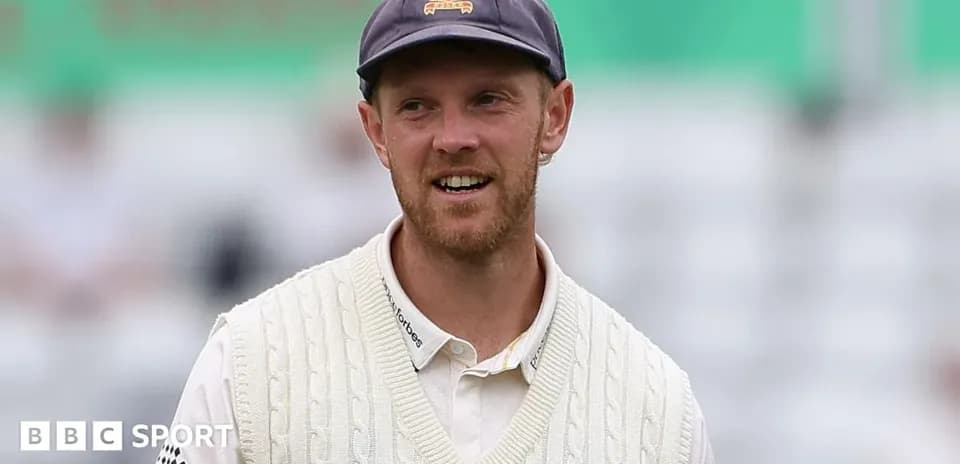 Cricketer wearing a white sweater and cap