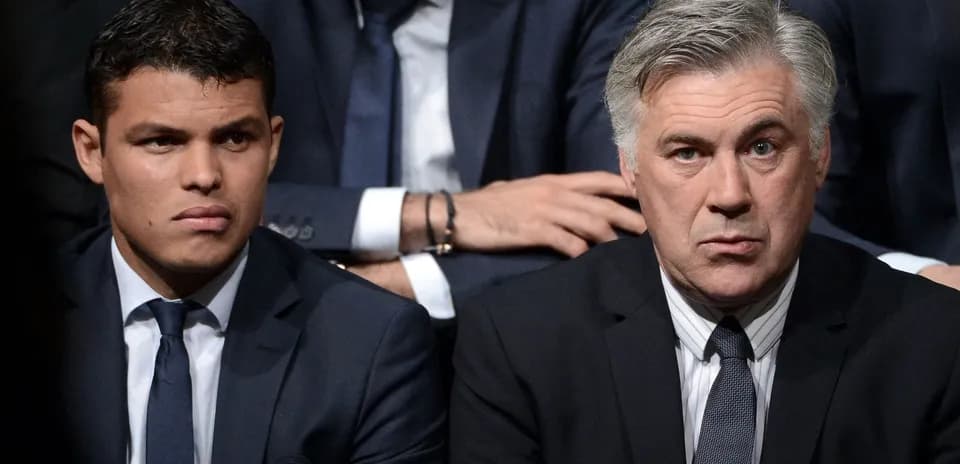 Two men in suits seated during an event