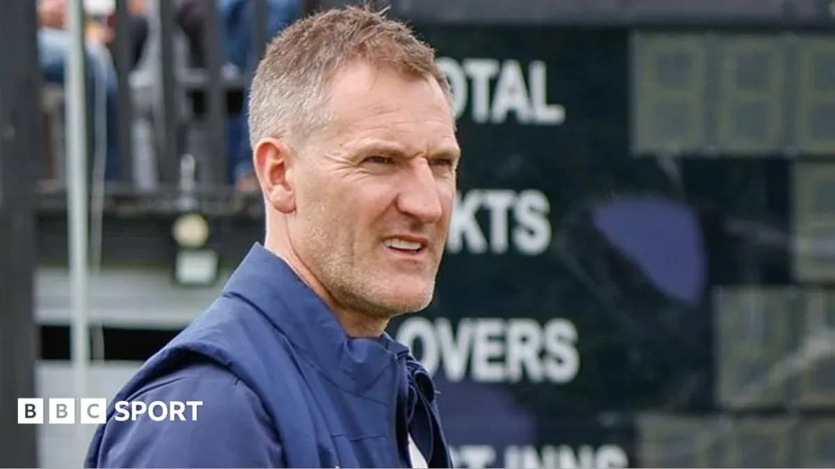Cricket coach observing match near scoreboard