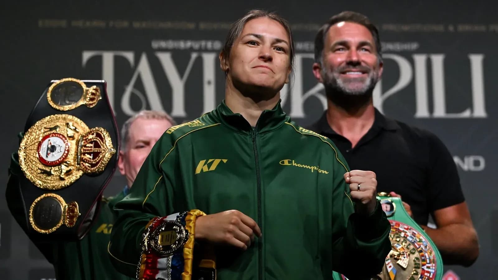 Boxer holding championship belts at press event