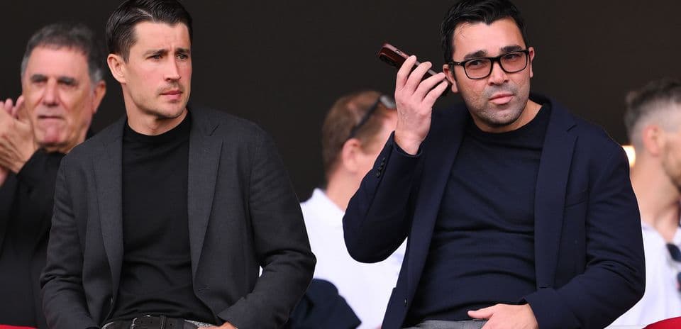 Two men seated in the stands during an event