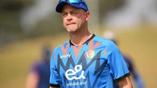 Cricket coach observing practice session on field