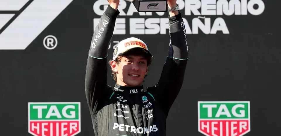 Driver celebrating victory with trophy at podium