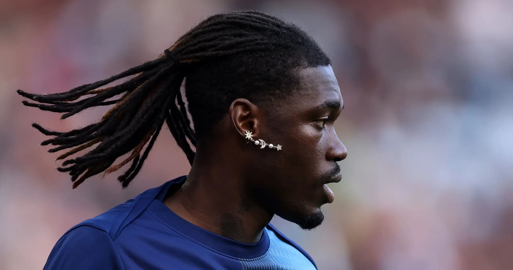 Player with dreadlocks and unique ear jewelry