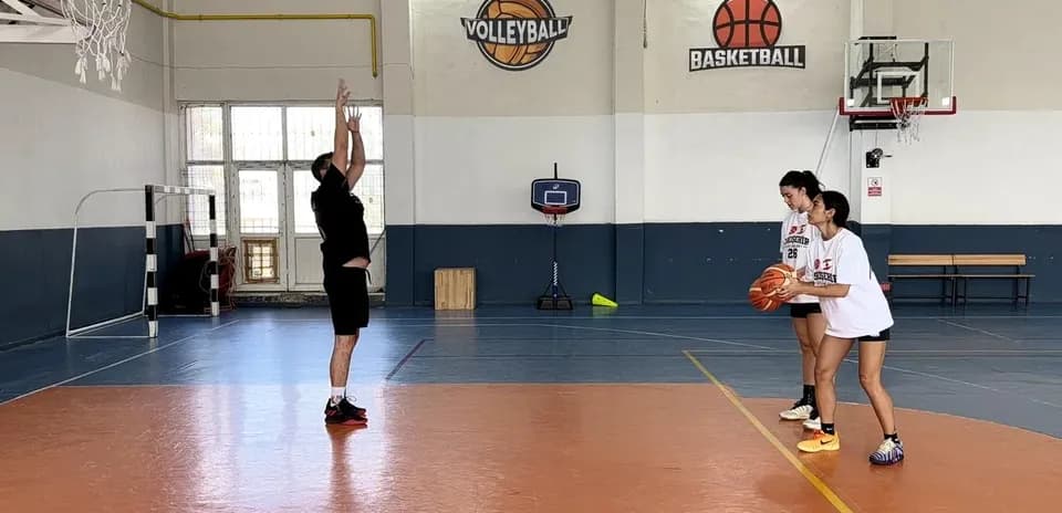 Coach instructing two players during basketball practice