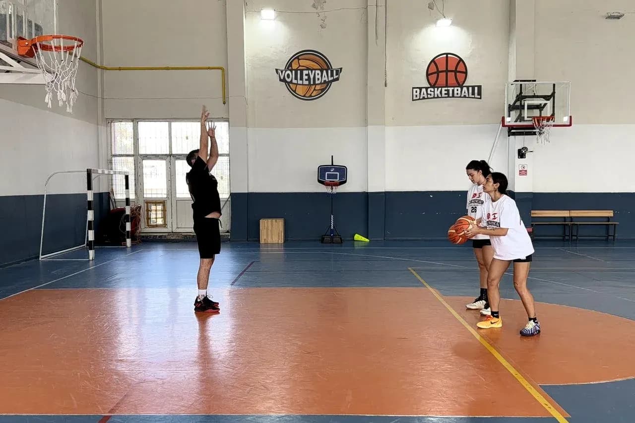 Coach instructing two players during basketball practice