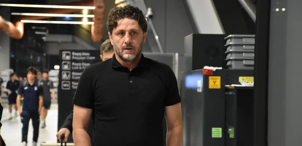 Man in black polo walking through airport terminal