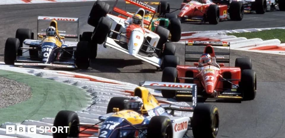 Several Formula 1 cars racing through a turn