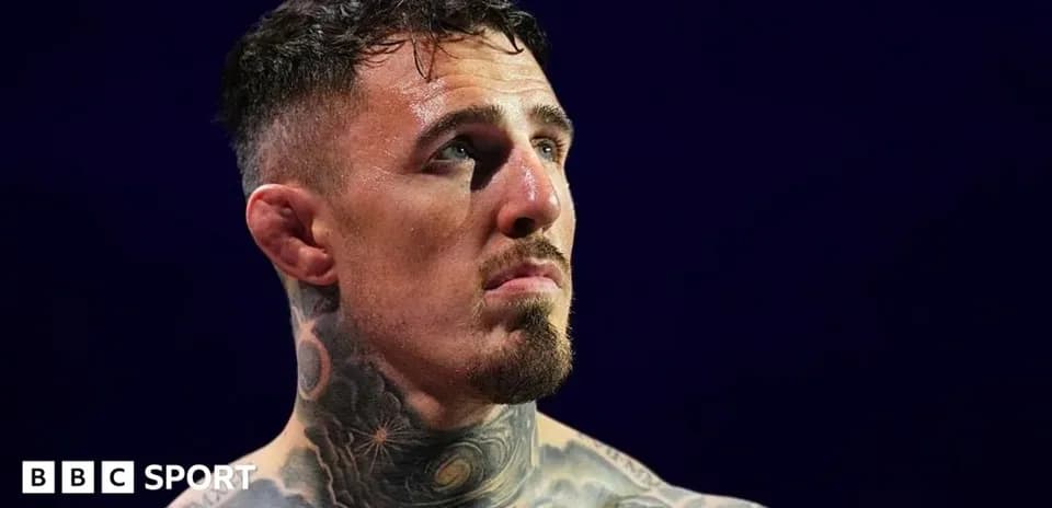 Tattooed fighter looking up during match