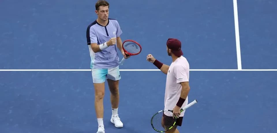 Two tennis players celebrating a point on court