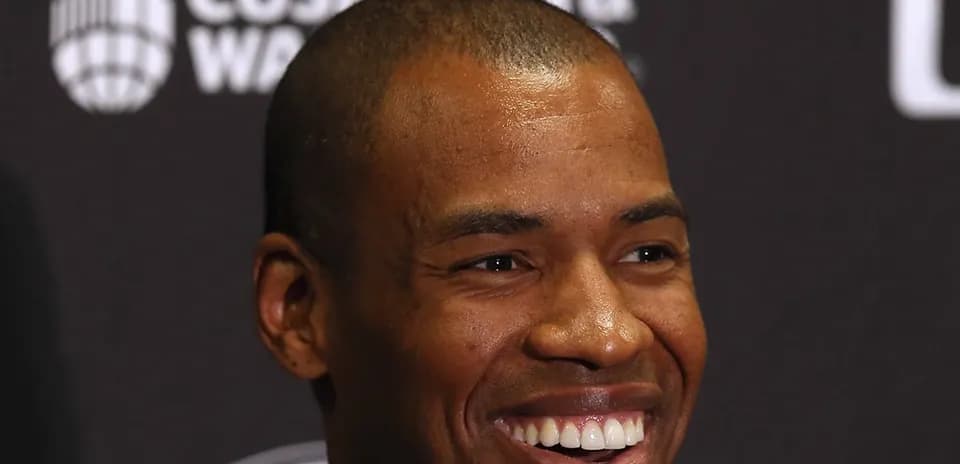 Smiling man at press conference with dark background
