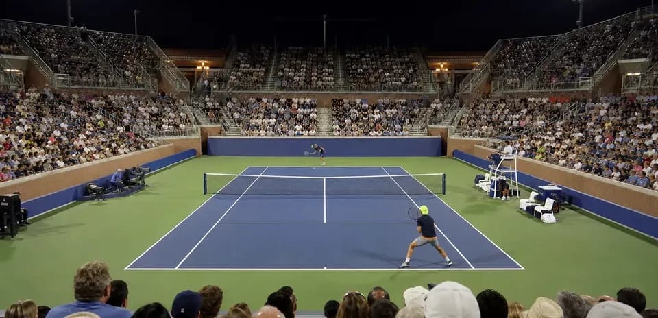 Night tennis match with spectators in the stands
