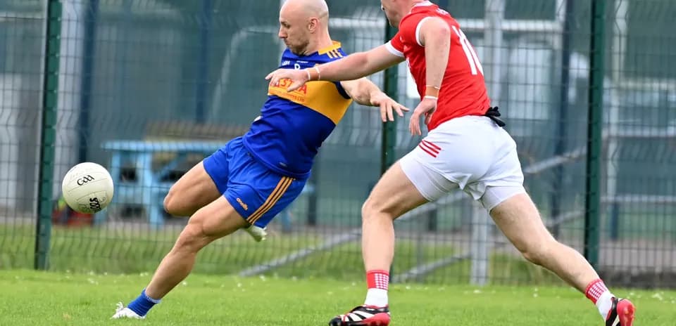 Player tackling opponent while kicking ball on field