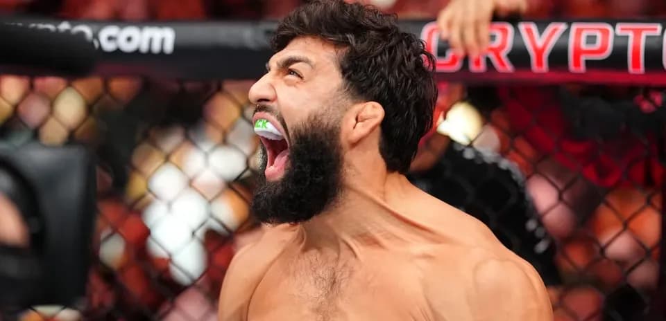 Fighter celebrating with mouthguard in UFC octagon