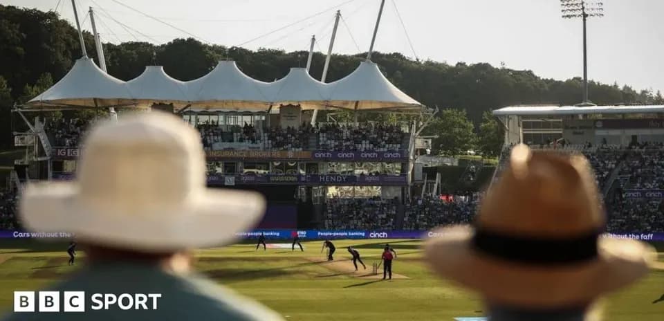 Cricket match in progress with spectators watching