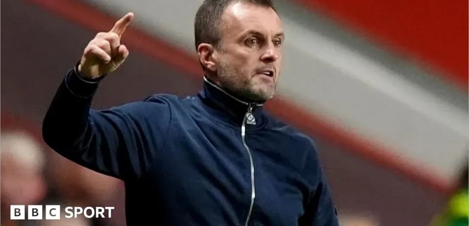 Manager gesturing during a match on the sidelines