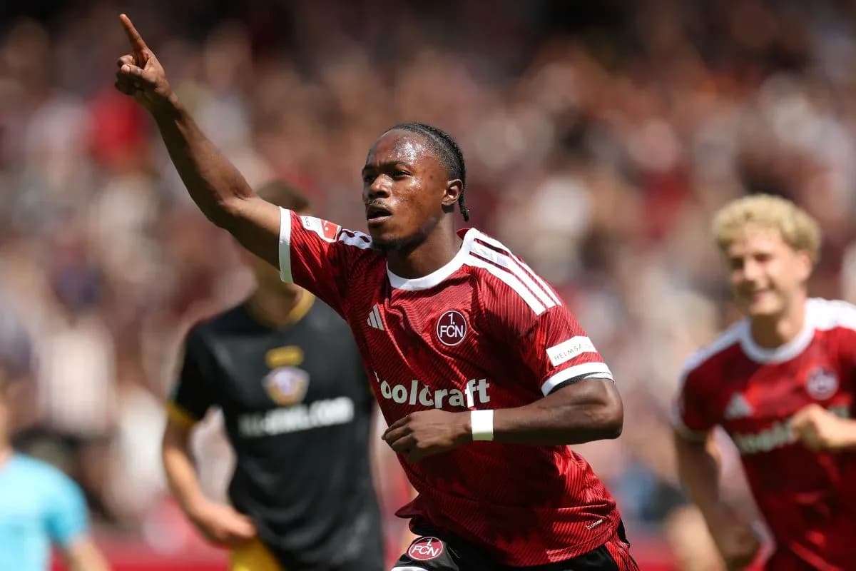 Player celebrating a goal with teammates in red jersey