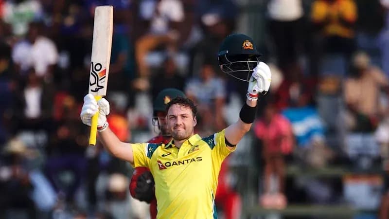 Batter celebrating a century with raised bat and helmet