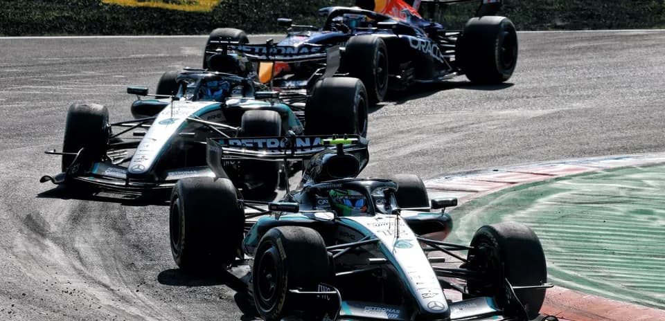 Three Formula 1 cars racing on track corner