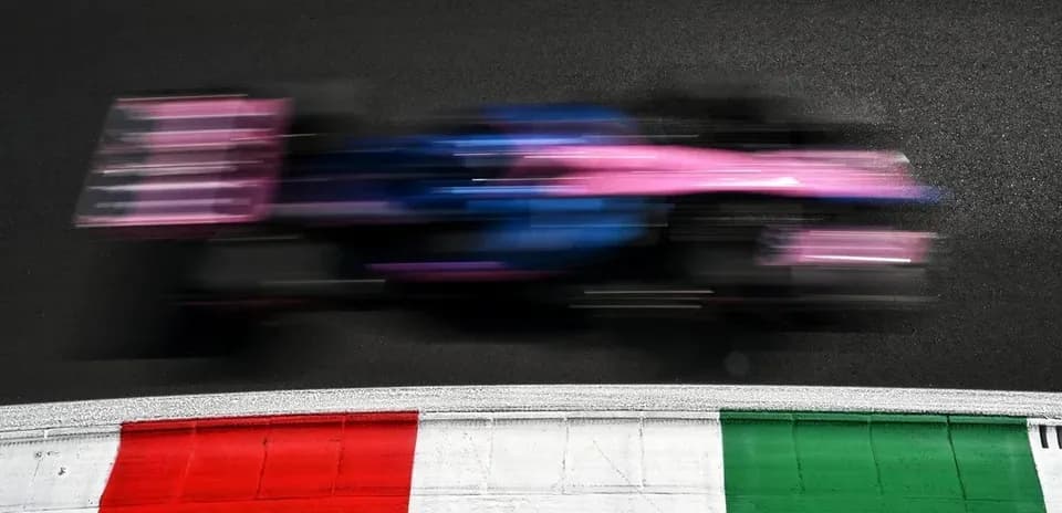 Formula 1 car racing past track curb