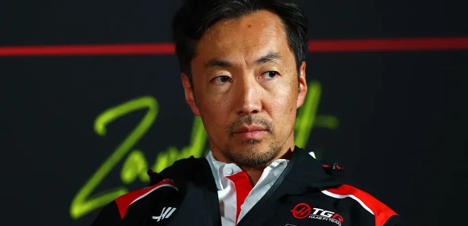 Team member during press conference with serious expression
