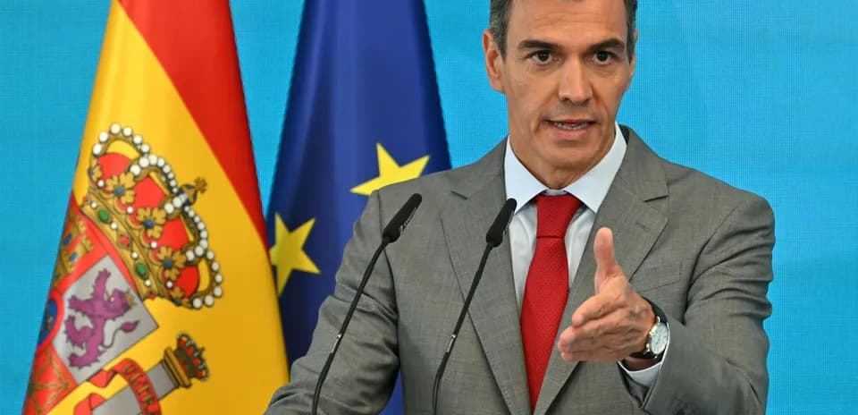 Man speaking at podium with flags behind