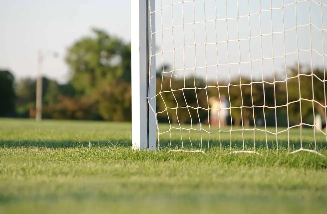 Close-up of soccer goal net on grass field