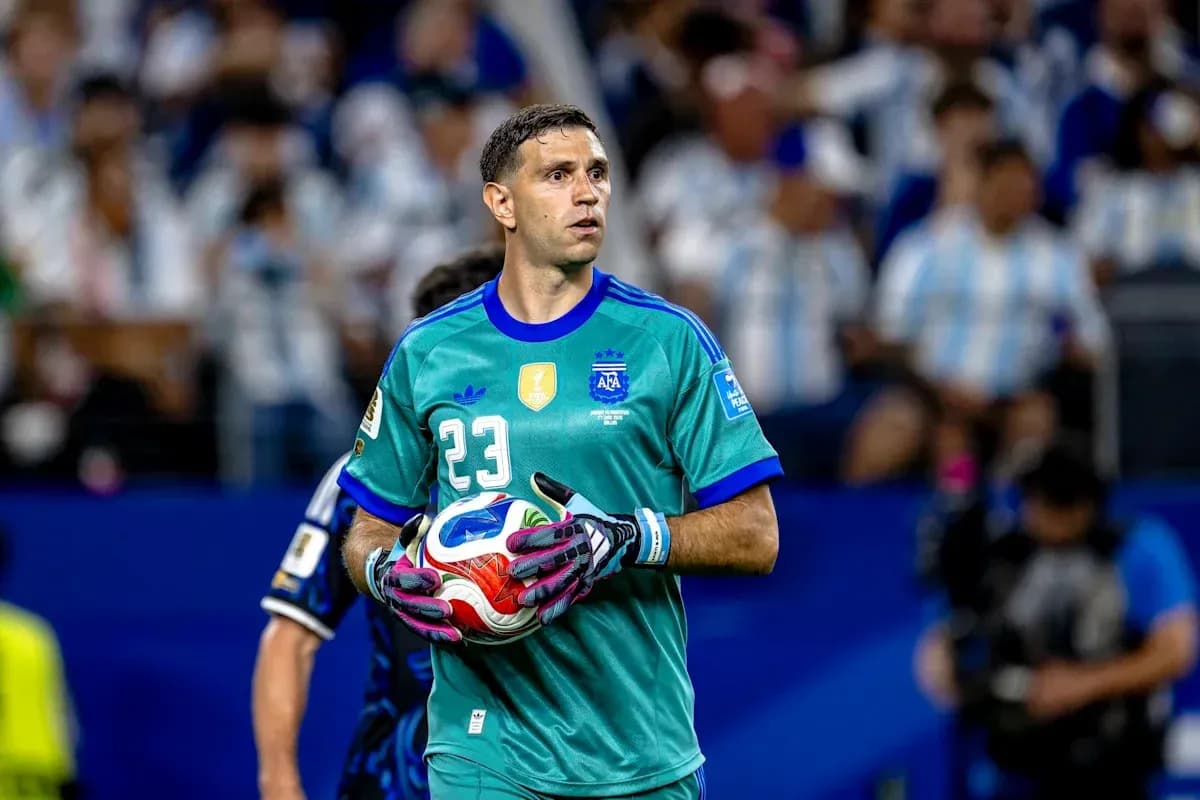 Goalkeeper in turquoise jersey holding a soccer ball