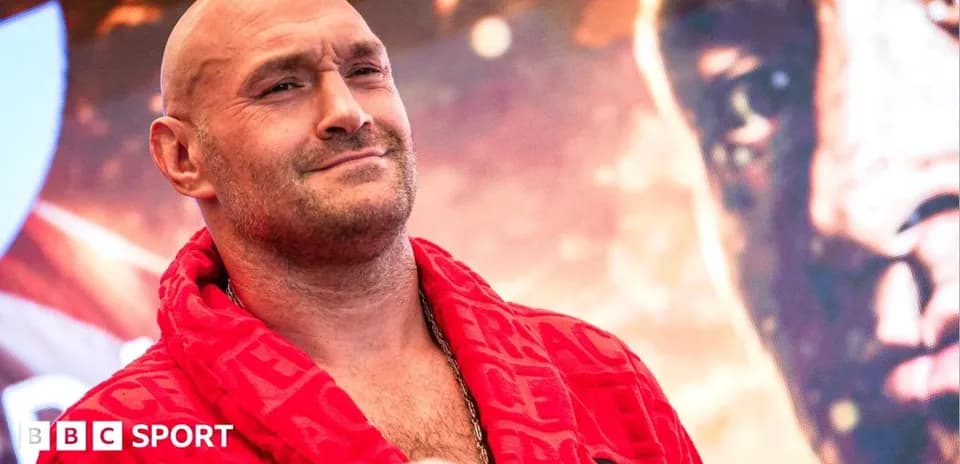 Boxer in red robe posing at promotional event