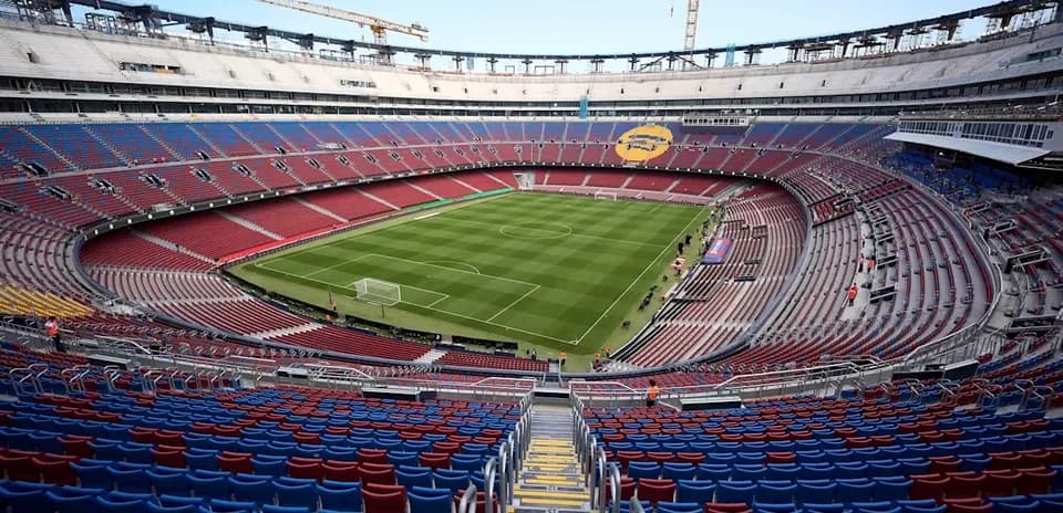 Empty stadium with green football pitch and seating