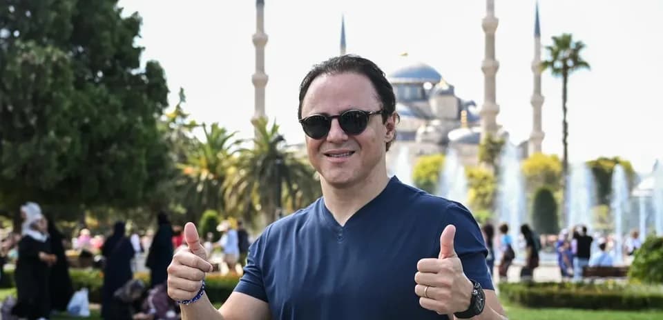 Man giving thumbs up with mosque in background