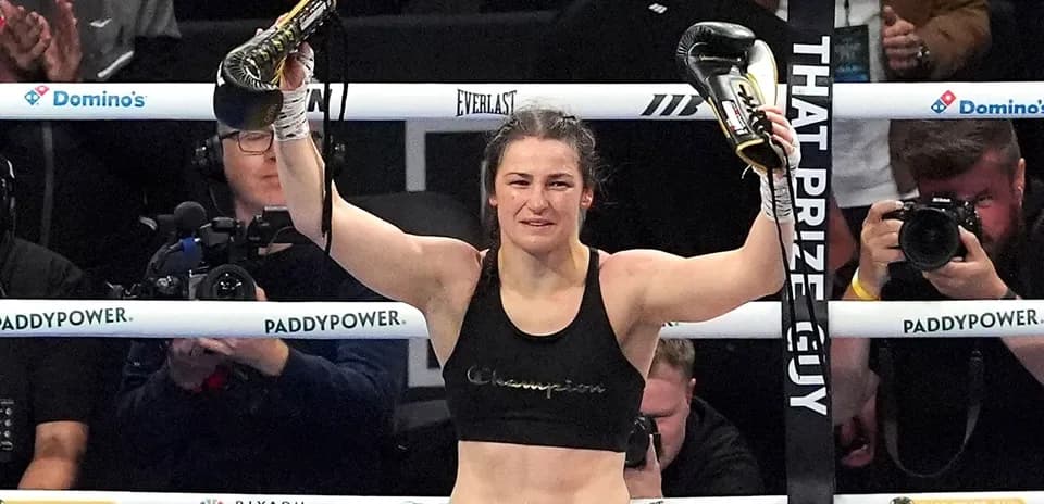 Boxer celebrating victory with gloves raised in ring