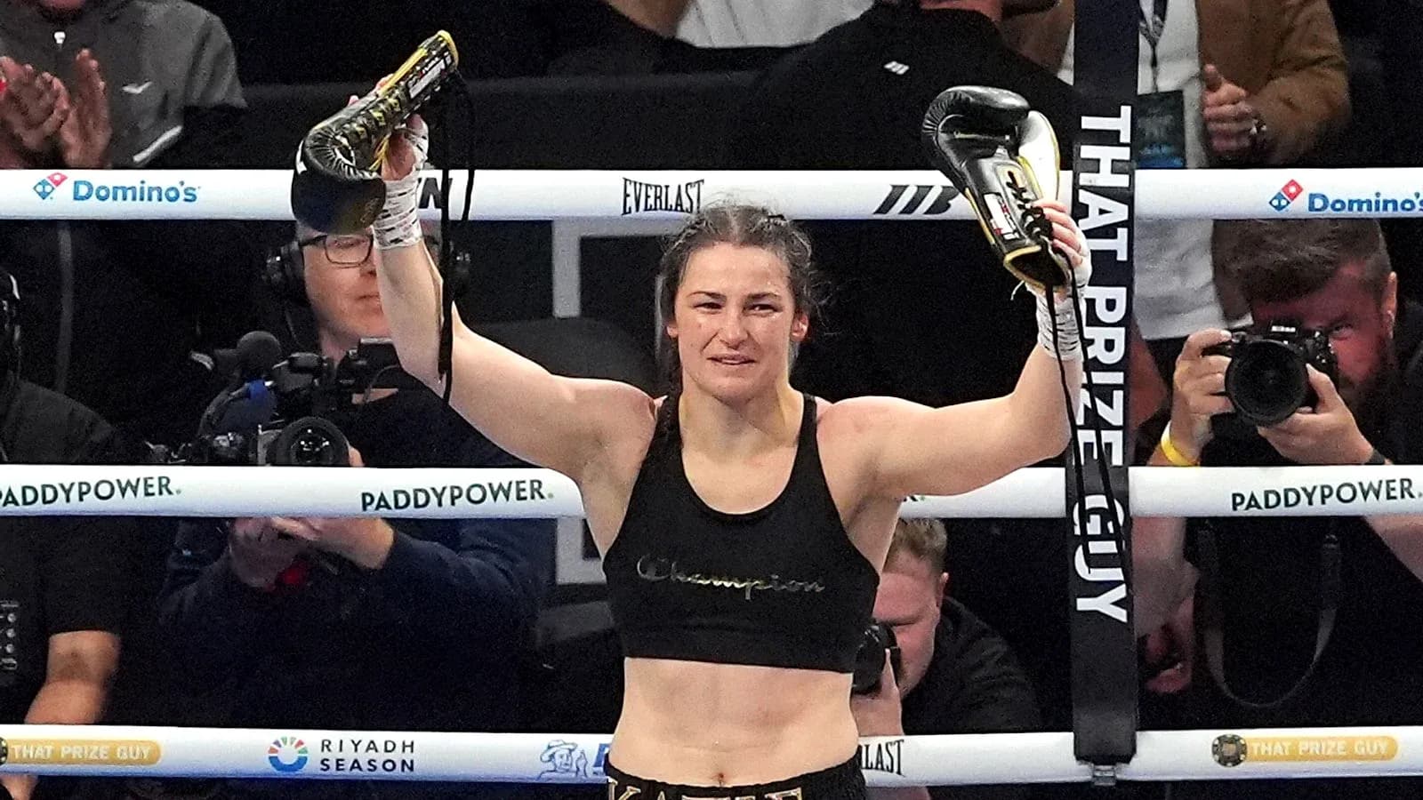 Boxer celebrating victory with gloves raised in ring