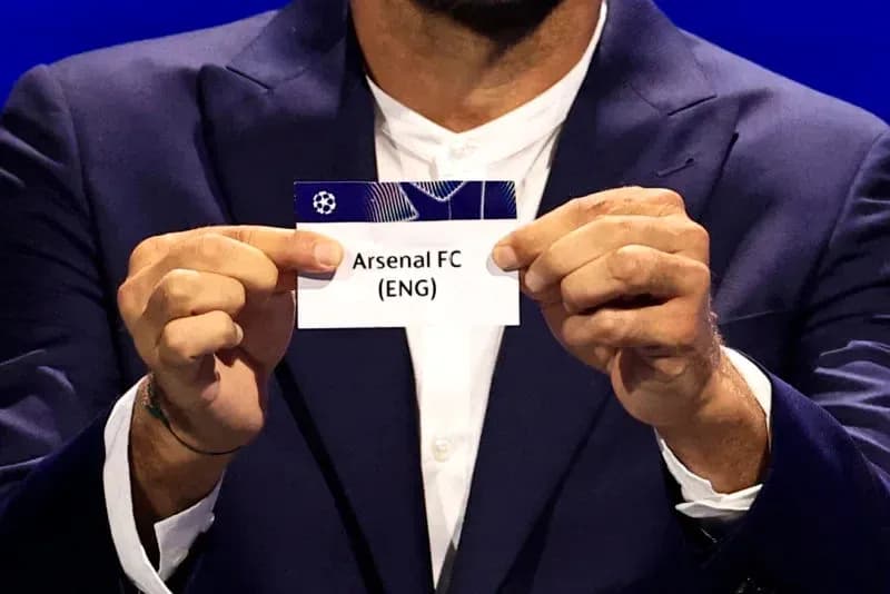 Person holding Arsenal FC draw card at event