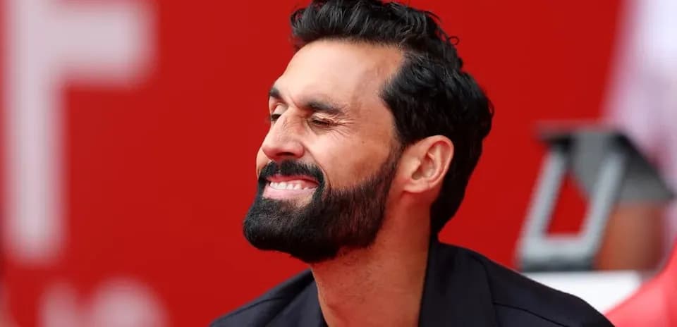 Man smiling and winking on the sidelines