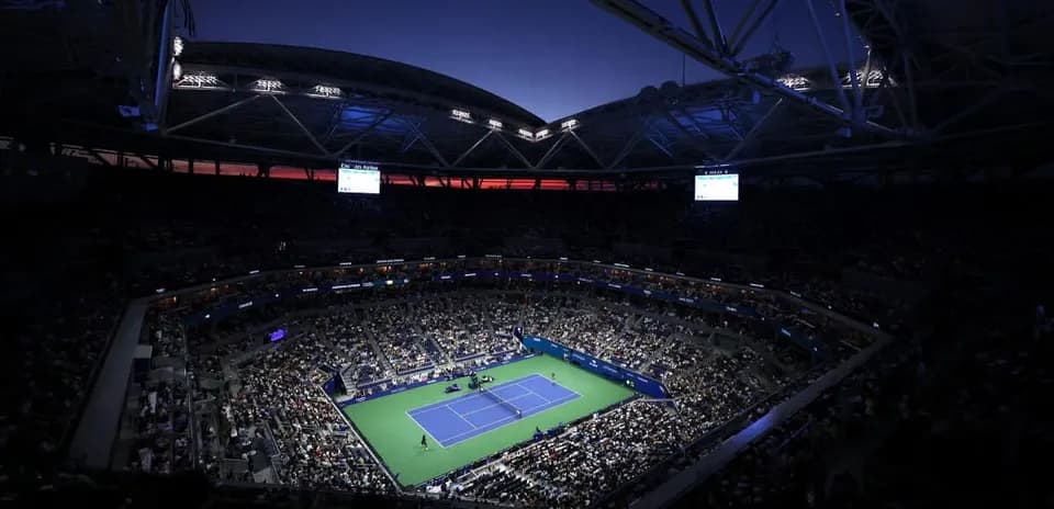 Crowd watching tennis match under stadium lights