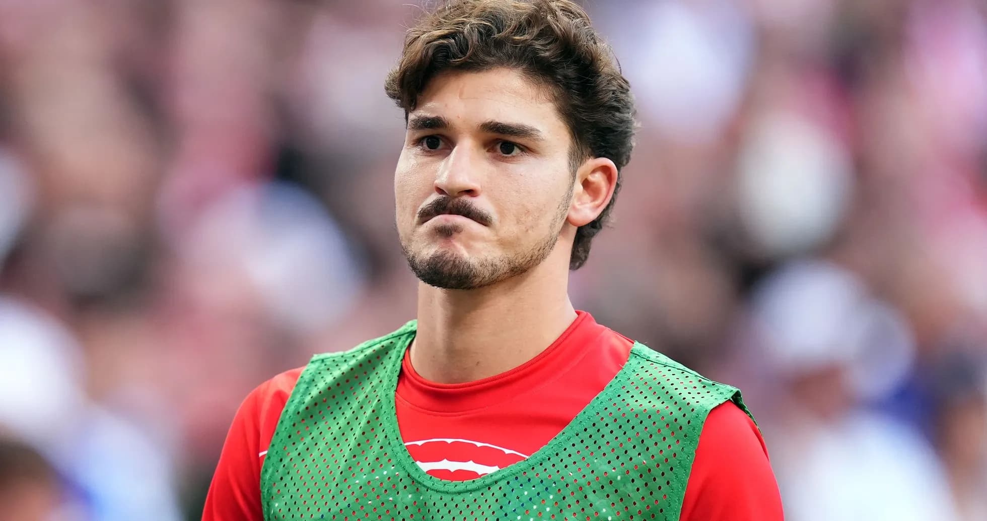 Player wearing training bib on sideline during match