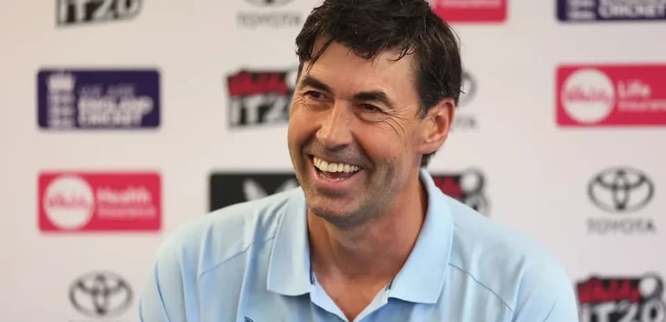 Cricket coach smiling at press conference