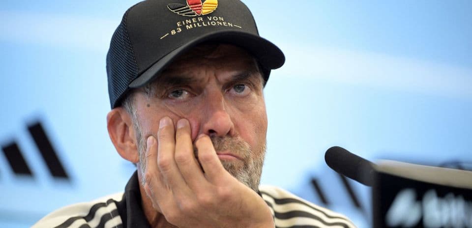 Coach at press conference resting chin on hand