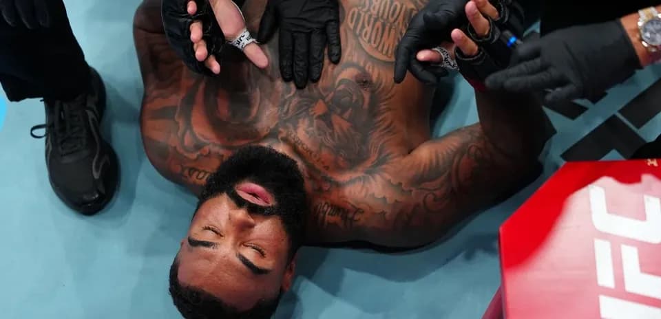 Fighter receiving medical attention on the mat