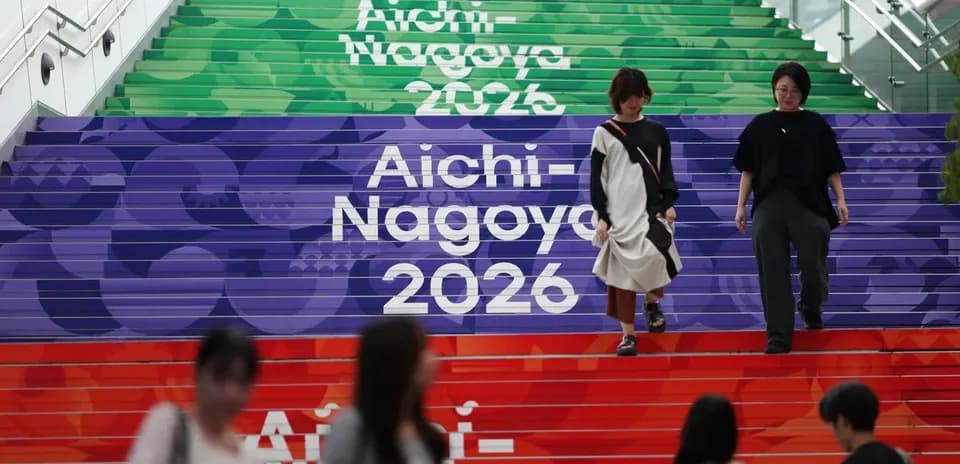 People walking down colorful stairs with event branding