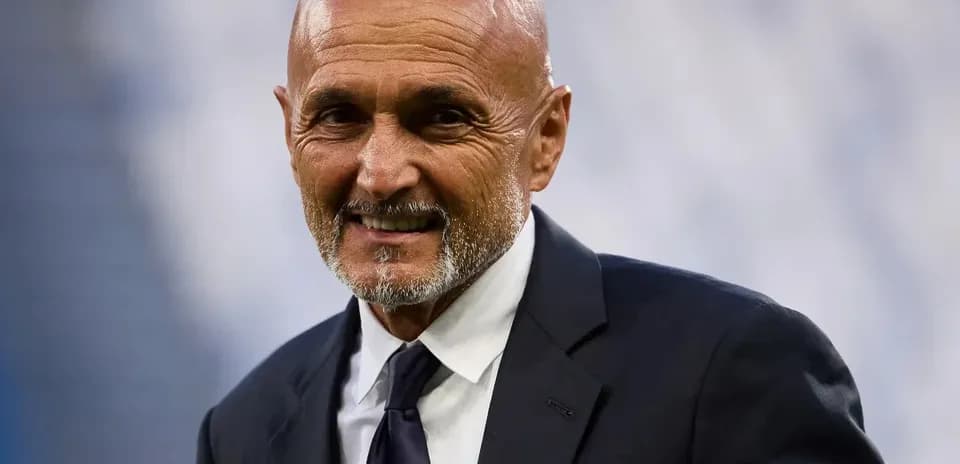 Man in suit smiling on the sidelines